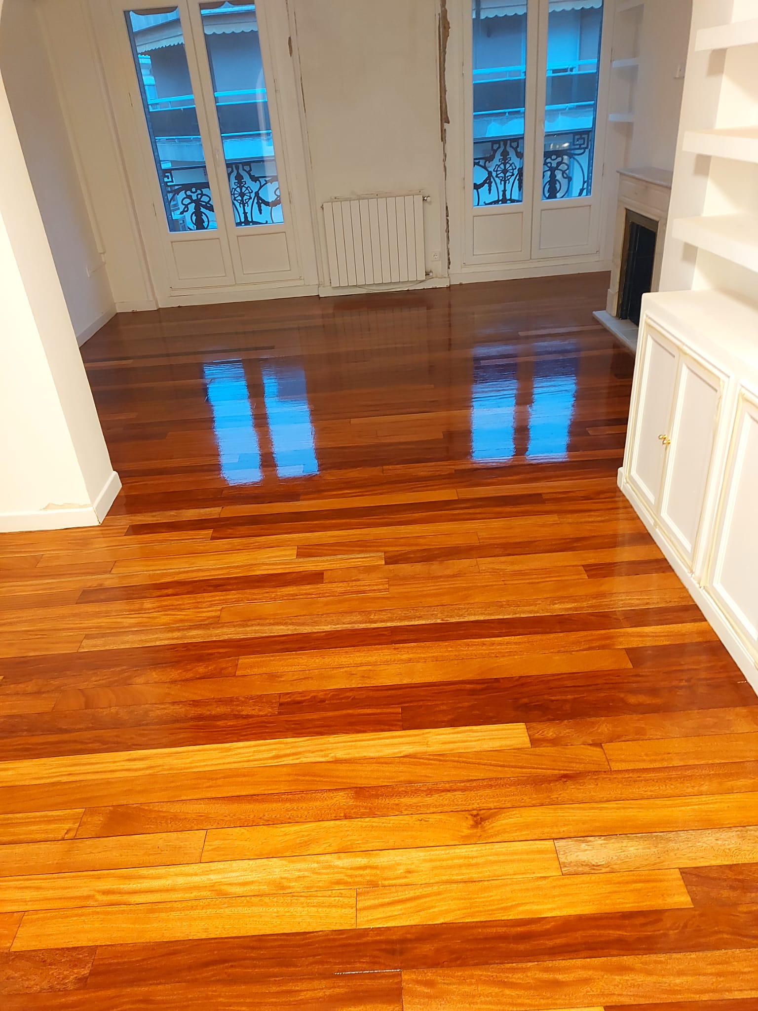 Suelo de parquet de madera barnizado con barniz brillante, lijado y barnizado profesional